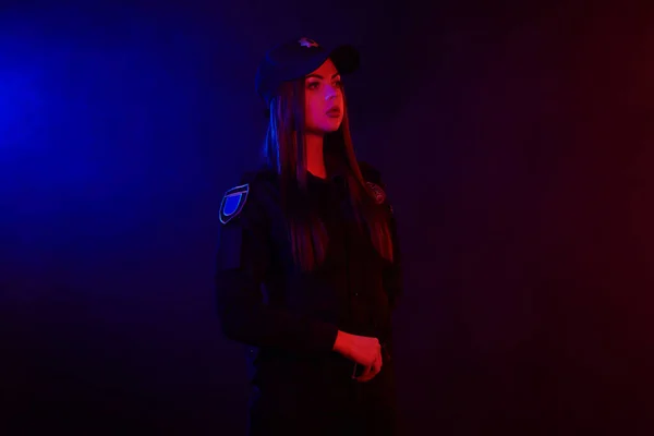 Serieuze Vrouwelijke Politieagent Poseren Voor Camera Tegen Een Zwarte Achtergrond — Stockfoto