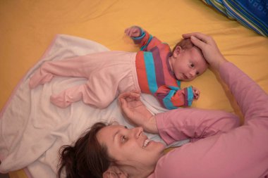 Anne evde bebekle oynuyor.