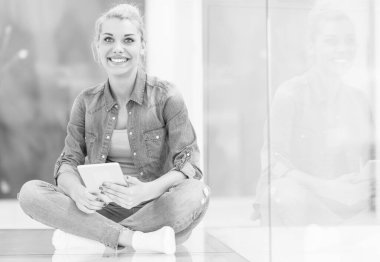 genç kadın yerde tablet bilgisayar kullanarak