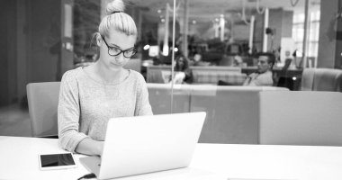 başlangıç ofisinde bir dizüstü bilgisayar kullanarak iş kadını