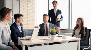 Beyin fırtınası. Birlikte dizüstü bilgisayara bakan bir grup iş adamı..