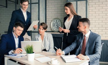 Beyin fırtınası. Birlikte dizüstü bilgisayara bakan bir grup iş adamı..