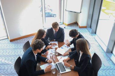 Girişim ekibi, modern parlak ofis içi beyin fırtınası, dizüstü bilgisayar ve tablet bilgisayar üzerine toplantı üzerine çalışıyor