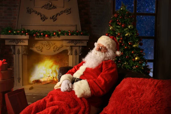 Święty Mikołaj Odpoczywa Wygodnym Fotelu Przy Kominku Domu — Zdjęcie stockowe