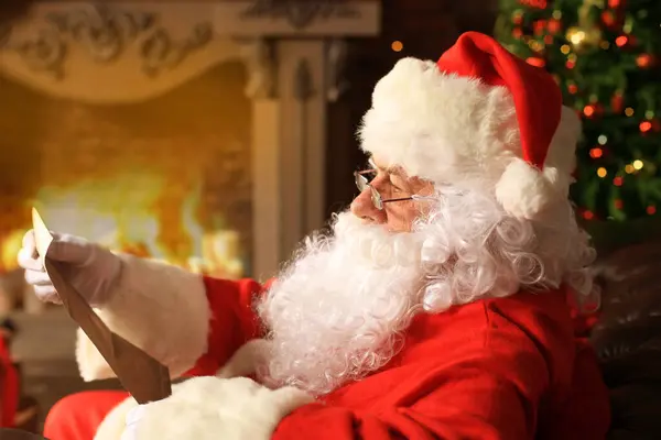 幸せなサンタクロースの肖像クリスマスツリーの近くの自宅で彼の部屋に座って クリスマスの手紙や願いのリストを読む — ストック写真