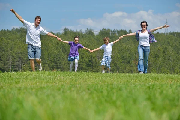 幸せな若い家族が屋外に楽しい時を過す — ストック写真