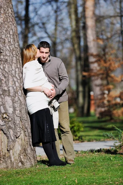 Couple posing outdoors, happy pregnancy concept