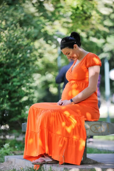 Zwanger Vrouw Een Oranje Jurk Poseren Buiten Gelukkig Zwangerschap — Stockfoto