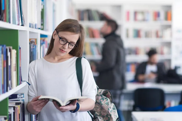 stock image portrait of female student reading book in library