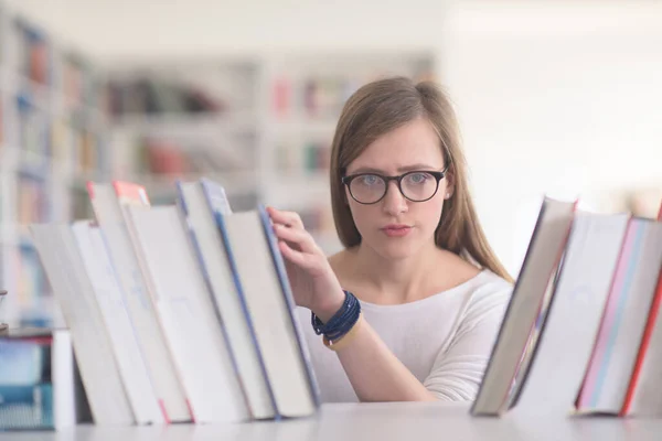 図書館で読む本を選択する女子学生の肖像画 — ストック写真