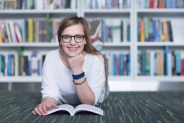 kız öğrenci kütüphanede çalışıyor, tablet kullanıyor ve internetten bilgi arıyor