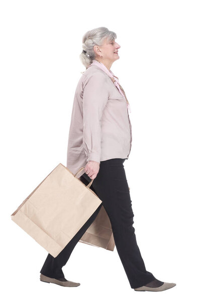 smiling old lady with shopping bags striding forward