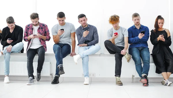 Groep Van Casual Jongeren Met Smartphones Zit Een Rij — Stockfoto