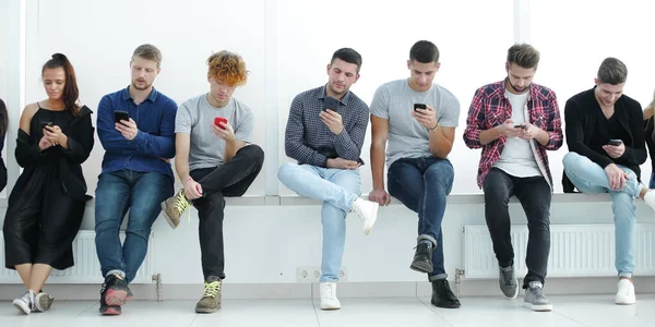 Groep Van Casual Jongeren Met Smartphones Zit Een Rij — Stockfoto