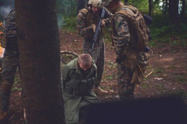 Askerler tarafından ormanda sorguya çekilen adam.