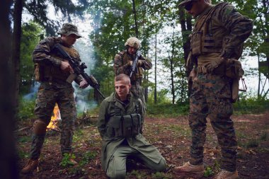 Askerler tarafından ormanda sorguya çekilen adam.