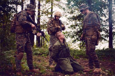 Askerler tarafından ormanda sorguya çekilen adam.