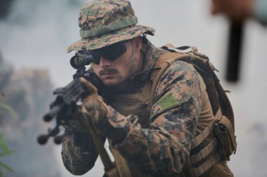 Asker lazer görüşlü optik kullanarak silaha nişan alıyor