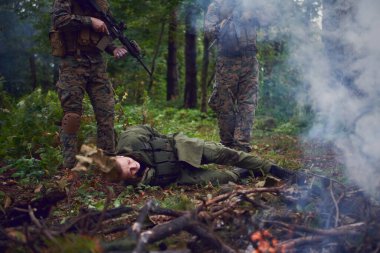Askerler tarafından ormanda sorguya çekilen adam.