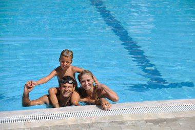 Mutlu genç aile yüzme havuzunda iyi eğlenceler.