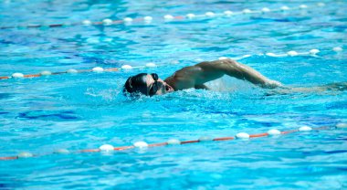 Erkek sporcu yüzme havuzunda yüzüyor 