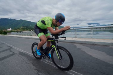 Sabah antrenmanında bisiklet süren triatlon sporcusu.