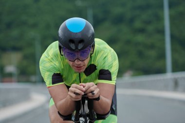 Sabah antrenmanında bisiklet süren triatlon sporcusu.