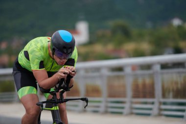 Sabah antrenmanında bisiklet süren triatlon sporcusu.