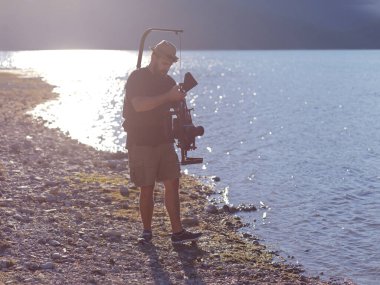 kameraman triatlon yüzme sporcusunun aksiyon fotoğrafını çekiyor