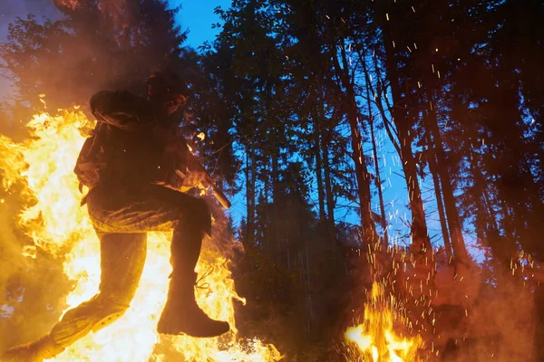 stock image Soldier in Action at Night jumping over fire