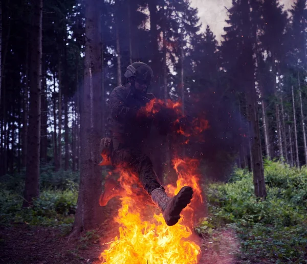 夜の行動中の兵士は火の上を飛び越える — ストック写真