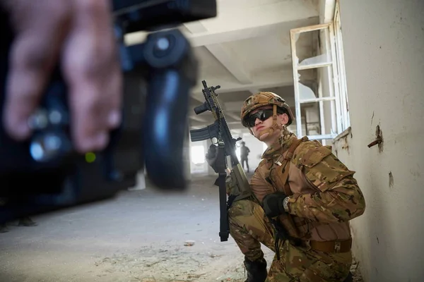 soldier in action near window changing magazine and taking cover