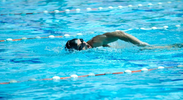 男性アスリートは水泳プールで泳いでいます — ストック写真