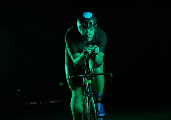 三项全能运动员夜间骑自行车跑得很快 — 图库照片