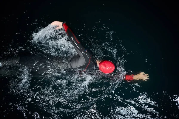 어두운 잠수복을 수영하는 트라이애슬론 — 스톡 사진