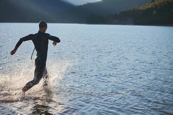 陸上競技選手が湖で水泳の練習を始め — ストック写真
