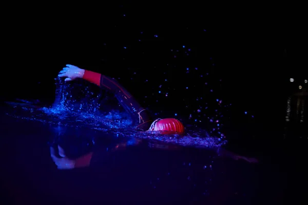 真のトライアスロン選手は暗い夜に泳ぎ — ストック写真