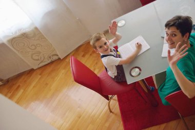 Anne küçük oğluna ödevlerinde yardım ediyor.