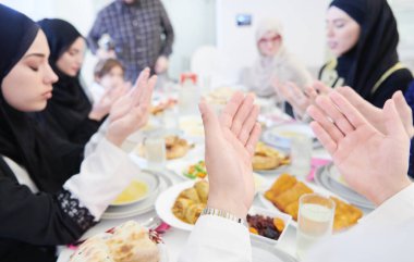 Geleneksel Müslüman ailesi iftar yemeğinden önce dua ediyor