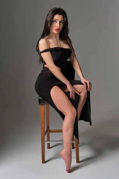 Joven Atractiva Morena Sexy Mujer Sienta Silla Vestido Cóctel Negro — Foto de Stock