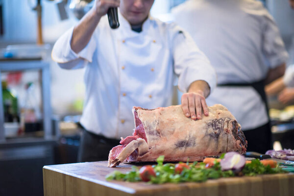 "chef cutting big piece of beef"