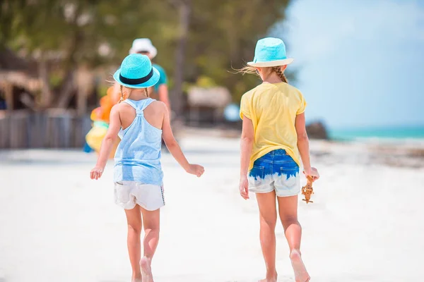 小さな幸せな面白い女の子は熱帯のビーチで一緒に遊んで楽しいことがたくさんあります 海に雨が降る晴れた日 — ストック写真