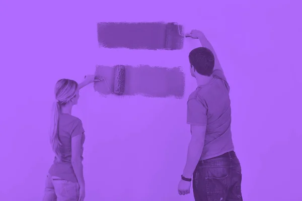 young couple painting wall at new home