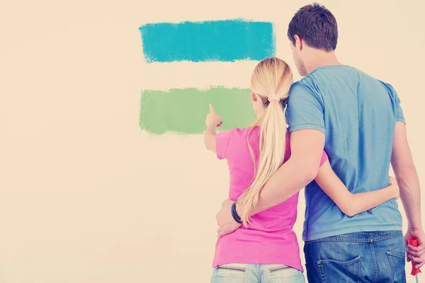 young couple painting wall at new home