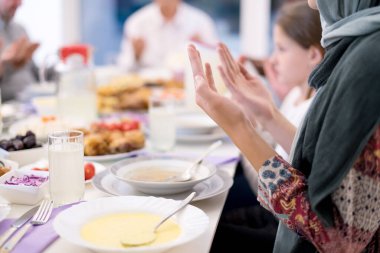 Modern çok ırklı Müslüman aile iftar öncesi dua ediyor.