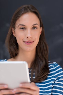 Tebeşir çizim kurulu önünde tablet kullanan kadın