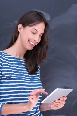 Tebeşir çizim kurulu önünde tablet kullanan kadın