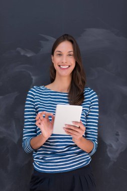 Tebeşir çizim kurulu önünde tablet kullanan kadın