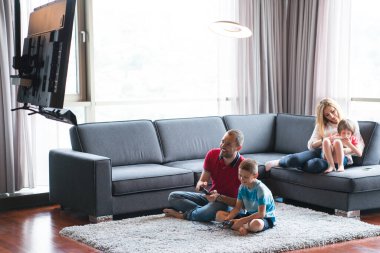 Video oyunu oynayan mutlu aile.