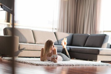 genç kadın yerde tablet bilgisayar kullanarak